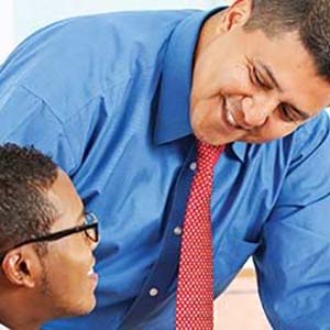 A smiling teacher interacting with a student.
